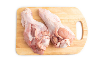 Raw turkey wing on a wooden cutting board isolated on white. Top view.