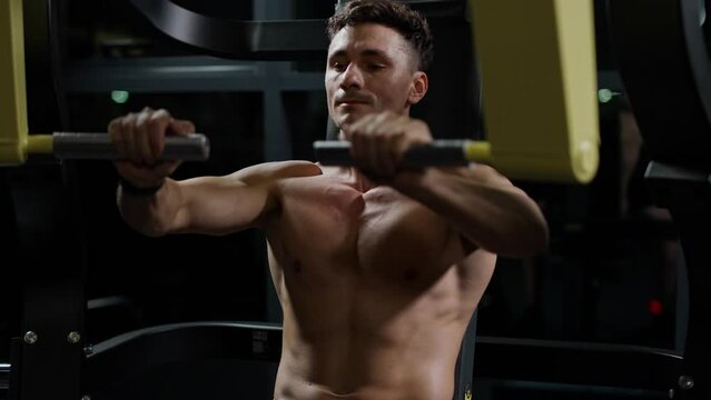 Motivation, athletic man in the Gym lifting blocks on gym machine, training on block device, 4k slow Motion.