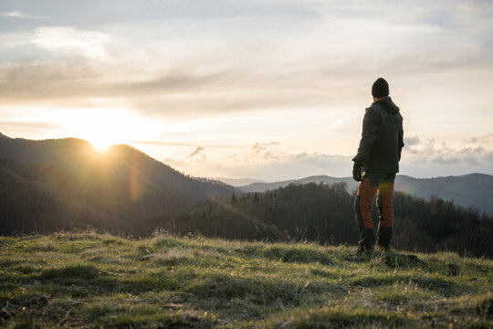 Male hiker looking at sunset in mountains