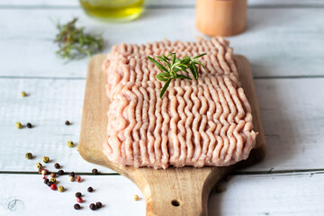 Raw ground turkey with rosemary and spices. Wooden on a white background.