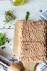 Raw ground turkey with rosemary and spices. Wooden on a white background.