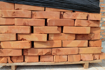 Red brick lies on a pallet in the yard