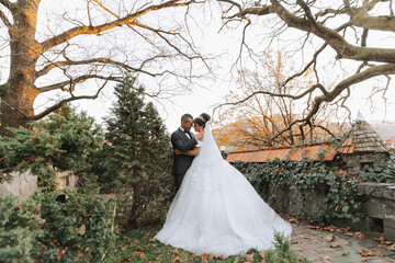 portrait of a happy wedding couple, bride and groom kissing in the autumn forest, park