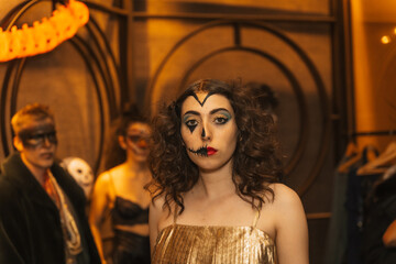 Halloween party with friends in a disco nightclub, portrait of a woman in costume with painted bed