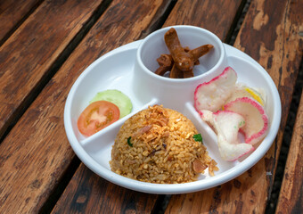 Nasi Goreng Sosis, sausage fried rice with white plate on wooden table