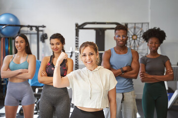 Multi-ethnic fitness group having fun in front of the camera at the gym 