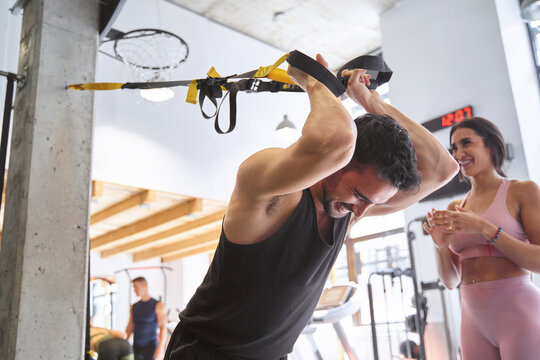 Fitness man exercising with suspension straps at the gym. Sports concept.