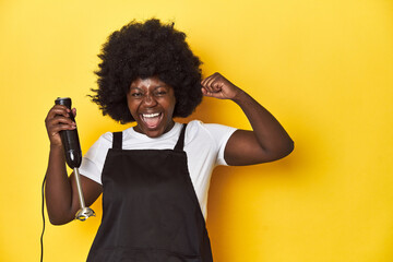 Home-baking woman with mixer, ready to create raising fist after a victory, winner concept.