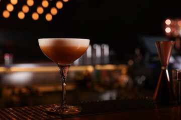 Glass of delicious Espresso Martini on bar counter, space for text. Alcoholic cocktail
