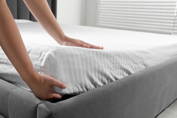 Obraz na płótnie Canvas Woman touching soft mattress indoors, closeup view