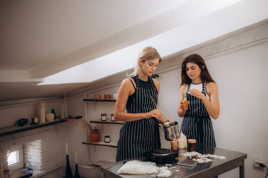 women dressed in aprons make a candle