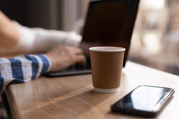 Businesswoman working on laptop computer and using mobile phone surfing the internet in coffee shop, close up, Woman online working from cafe, blogger or freelancer, telecommuting concept
