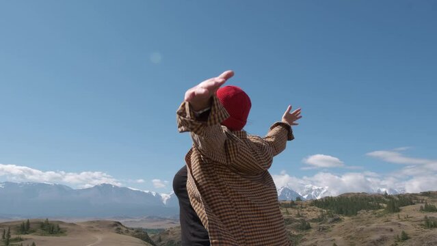 Happy Female Traveller Raising Hands Over Blue Sky In Mountains Background. Woman Smiling And Breathing Fresh Air. Freedom, Happiness And Traveling Concept.