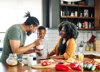 child family kitchen food boy son mother father breakfast cereal bowl morning healthy diet eating home black african american father man happy childhood cute meal preparing