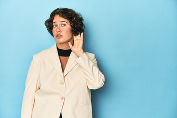 Young woman in elegant white blazer trying to listening a gossip.