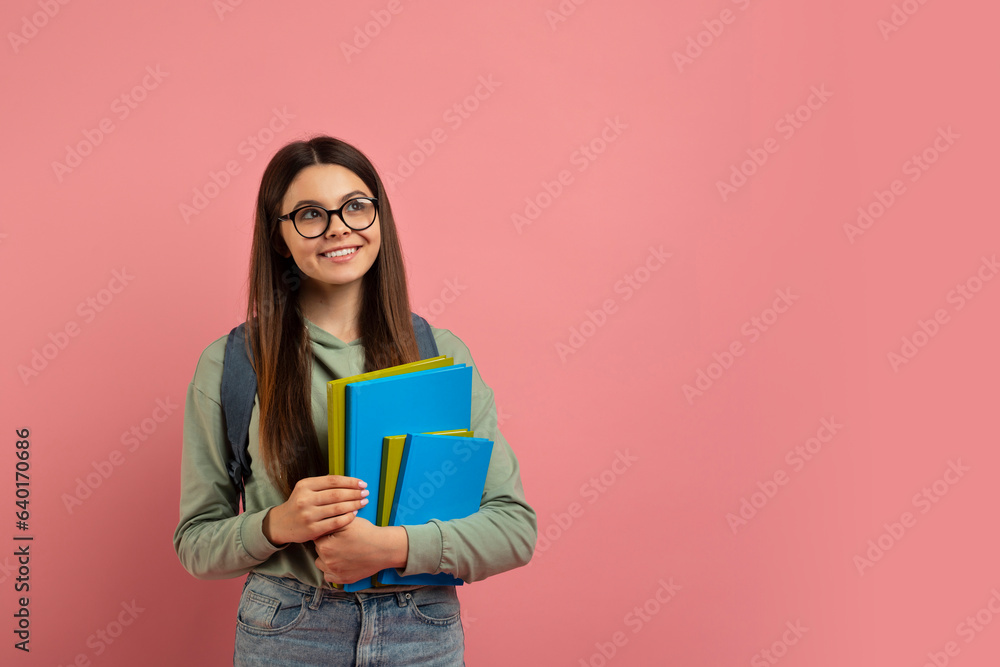 Wall mural Beautiful Teen Girl With Backpack And Workbooks Looking At Copy Space