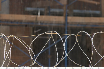 barbed metal wire on a fence.