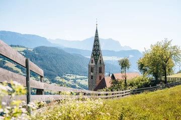 Fotobehang Church on a mountain overlooking valley in Villandro, Dolomites, Italy © Peter