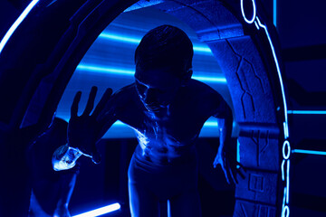 cosmic phenomenon, extraterrestrial humanoid near experimental equipment in neon-lit science center