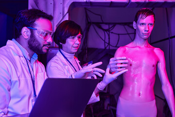 multiethnic scientists with laptop examining unknown cosmic visitor in futuristic science center