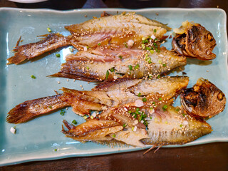  a variety of veggies and crispy fried fish on your plate.