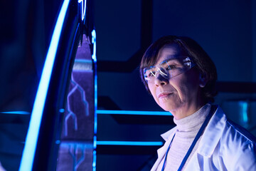 future-oriented middle aged scientist exploring experimental equipment discovery center