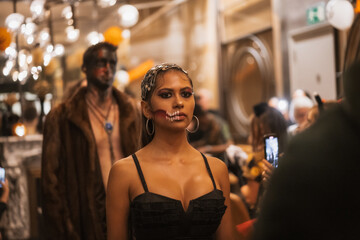 Portrait serious woman at halloween party with friends in disco nightclub
