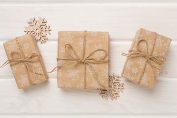 Fototapeta na wymiar Craft christmas gift boxes on wooden background, top view