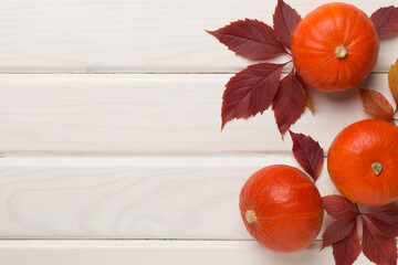 Flat lay with pumpkins, fruits and autumn leaves on wooden background, top view