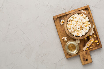 Prepared popcorn with ingredients on concrete background, top view