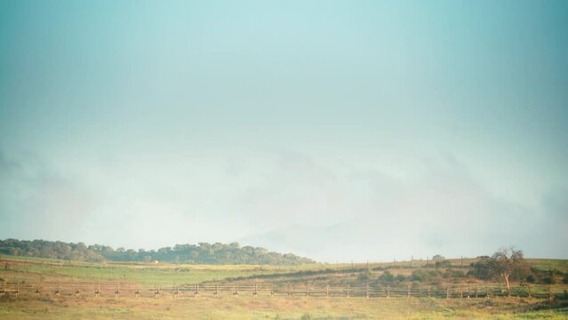 Time lapse of clouds moving over field country landscape and castle Mourao in the distance, district of Evora in Portugal Europe.