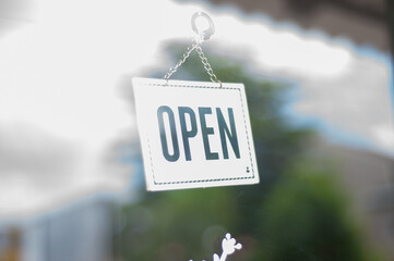 open sign in front of a shop - Powered by Adobe