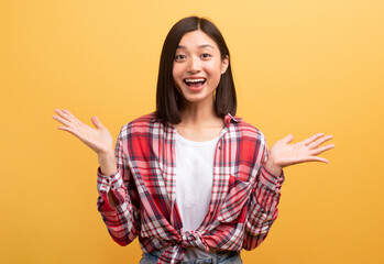 Emotional surprised chinese lady shouting in excitement spreading palms raising hands up standing...