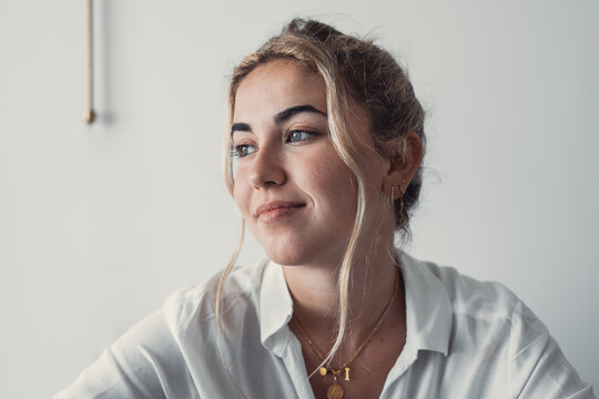 Smiling young caucasian business woman head shot portrait. Thoughtful millennial businesswoman looking away with pensive face, dreaming, thinking over project tasks, future lifestyle.