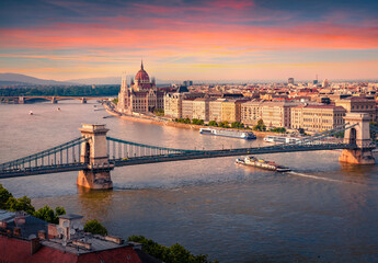 Fototapeta na wymiar Wonderful summer cityscape of Hungarian parliament building with famous Chain Bridge on the Danube river. Spectacular sunset in Budapest, Hungary, Europe. Traveling concept background..