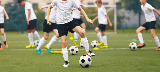 Football soccer school for youth boys. Group of teenage boys kicking soccer balls during a training...
