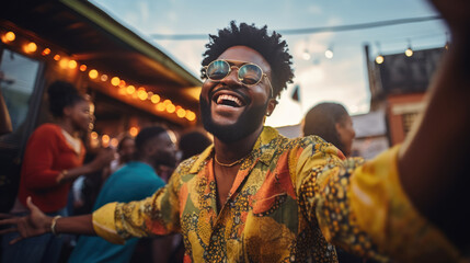 Young man dancing at outdoor party surrounded by friends.