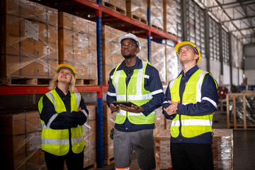 Industry warehouse worker in safety uniform check order details and checking goods supplies on boxes shelve in workplace warehouse industry logistic export import distribution business concept.