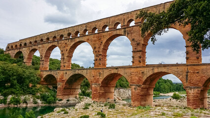 Obraz premium Panoramic view of ancient old Roman Aqueduct Pont du Gard ear Vers-Pon-du-Gard, Occitanie, France, Europe. Landmark over the River Gardon. Unesco world heritage site near Nimes, Languedoc-Roussillon