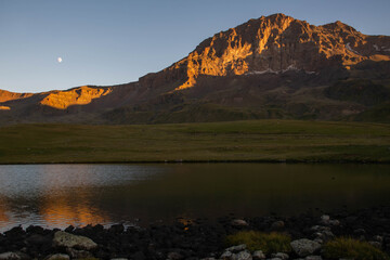 Small lake on top of a mountain. Crystal clear lake and mountain. Beautiful landscape with lake, fields and mountain