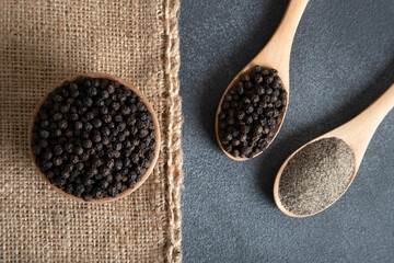 Ground black pepper with grains of black pepper on dark background