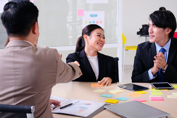 Businessmen smile, clap and shake hands during business meetings.