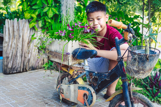 Asian boys have found old bicycles by turning them into flower pots for their homes.This creative idea not only makes use of discarded items but also creates a beautiful and sustainable garden design