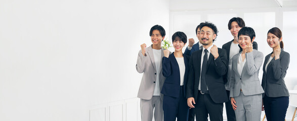 ガッツポーズする幅広い世代のビジネスパーソンのグループ