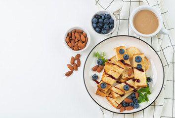 Breakfast with toasts , blueberries, almonds  and  coffee in  white tableware top view with copy space