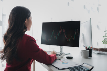 Asian woman looking at stock market graph screen, stock market businessman analyzing stock market...