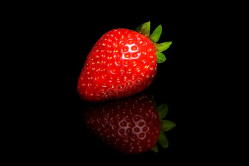 Red ripe strawberries on a black background.