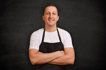 Male chef in apron looking at camera on dark background. Cooking concept - 640208459