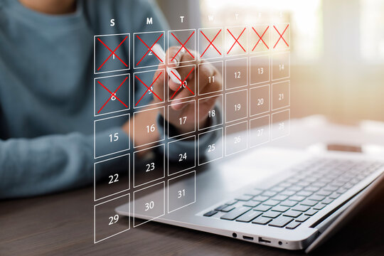 Business people use pen to write crossed-out online calendars and write a message on empty notebook paper while using a laptop to text messages, desktop view, Scheduling of meetings and appointments.