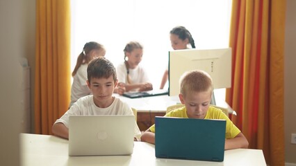 group of children study at home via lifestyle laptops. business concept of modern training and development. little kids are educated through the computer. two boys with laptops in the foreground